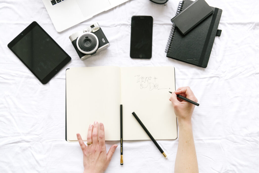 project management flatly of a business consultant hands writing on a notebook with tools and technology