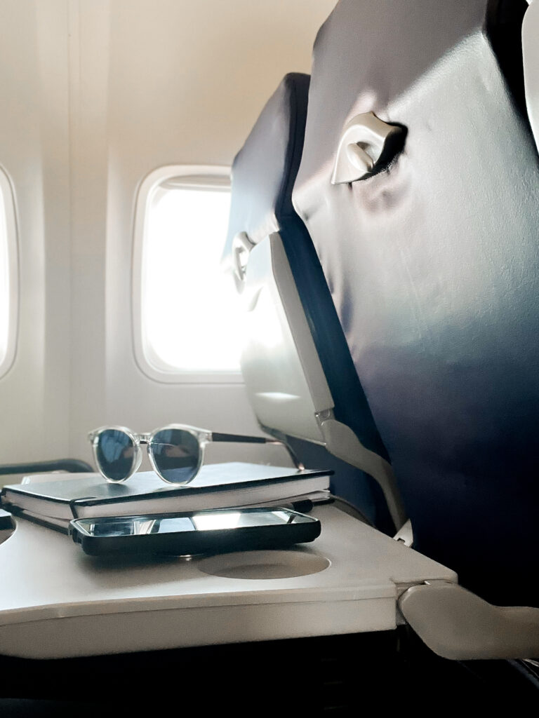 out of office message notebook and phone on an airplane table