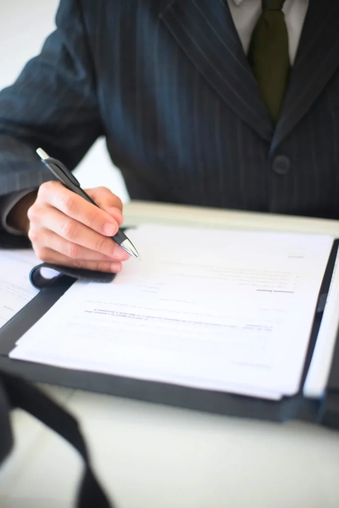 Person in a Suit Holds a Pen and Appears To Write Business Policies