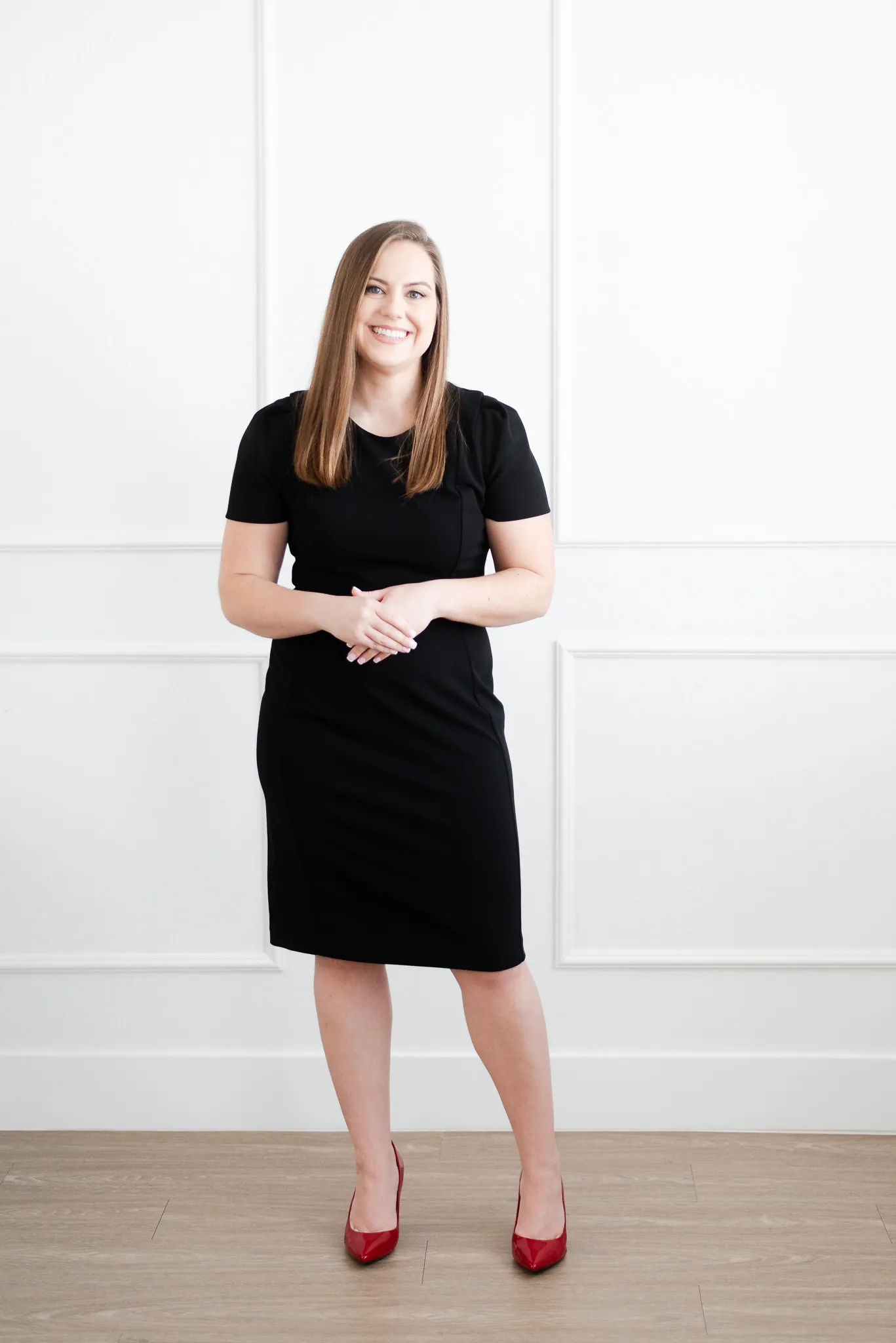Whitney in Black Dress Standing in Front of White Wall Whitney in Black Dress Standing in Front of White Wall