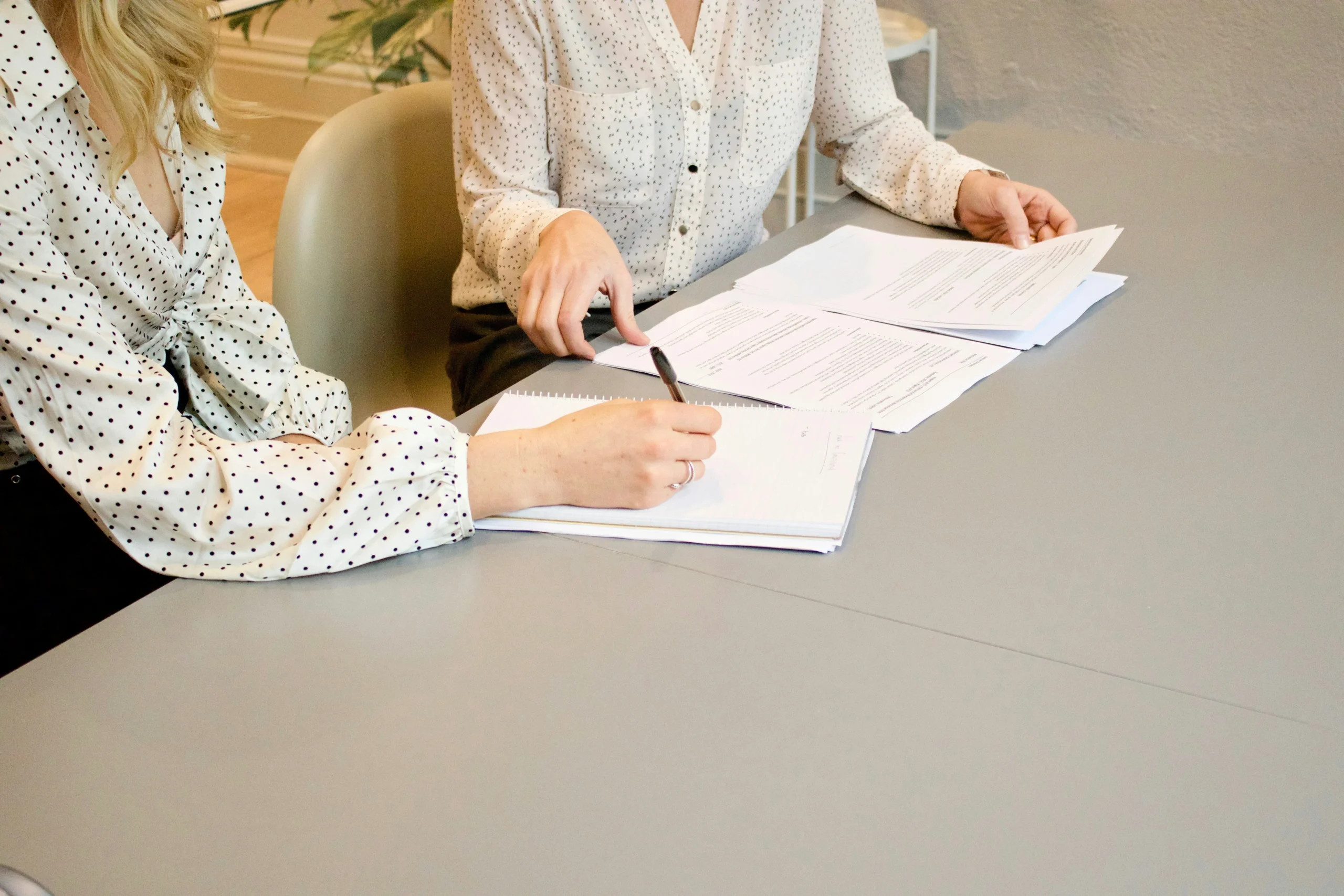 2 Women in White Blouses Consulting Paperwork 2 Women in White Blouses Consulting Paperwork