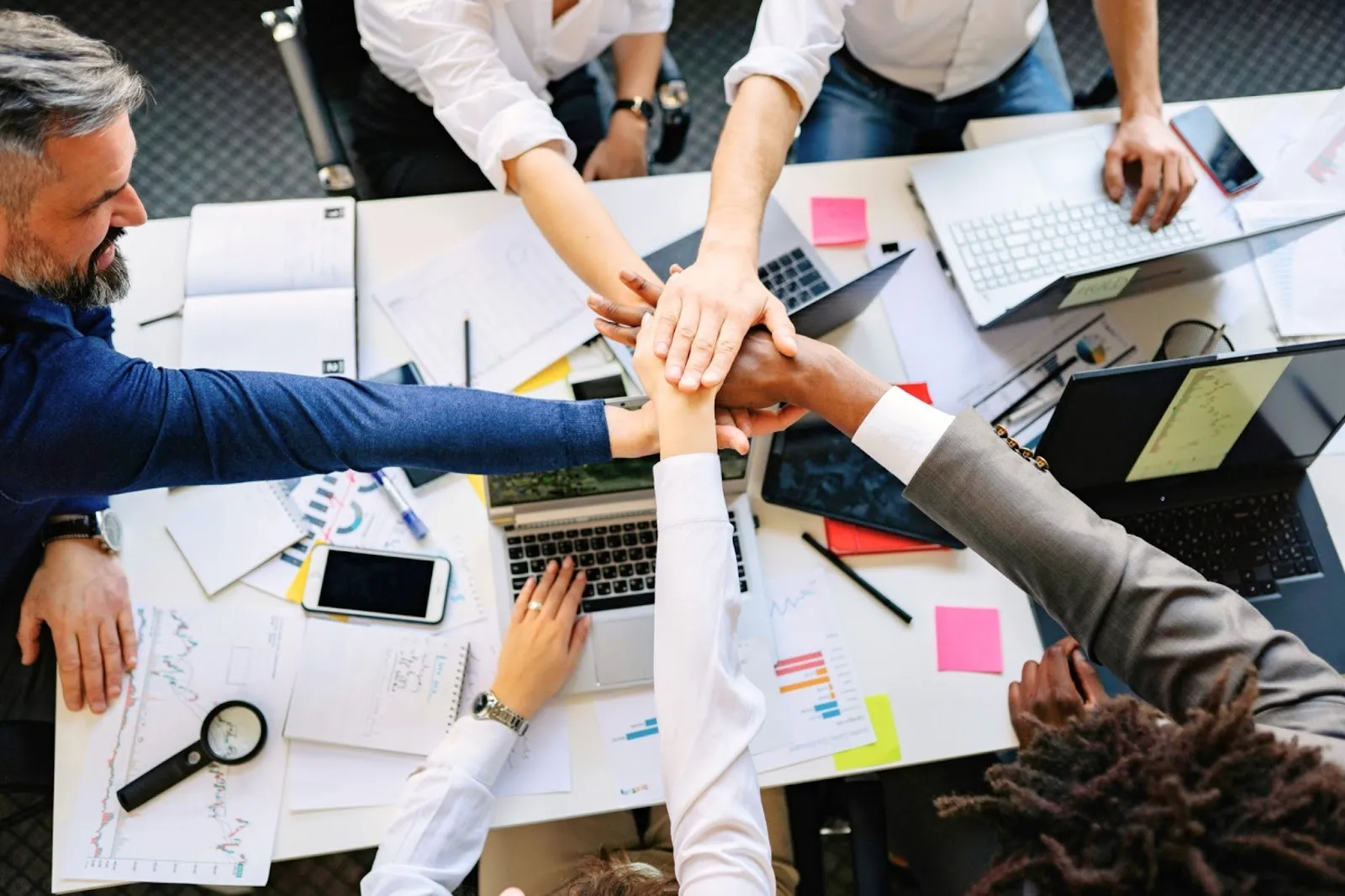 People putting hand together over a table