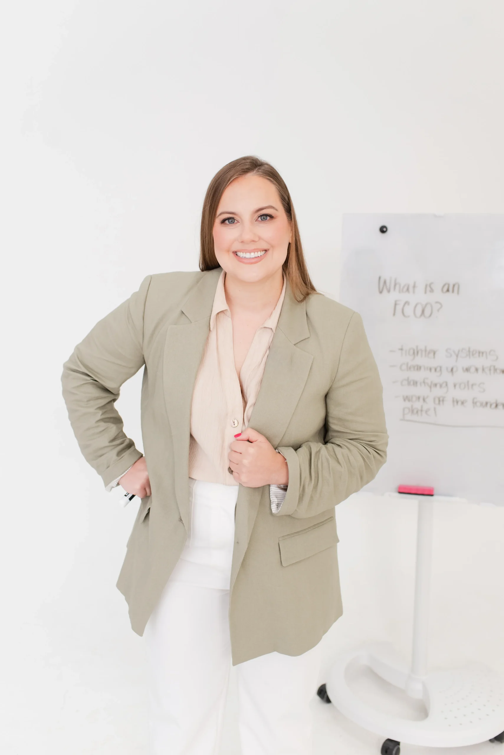 Whitney in Tan Jacket Standing in Front of White Board Stating fCOO