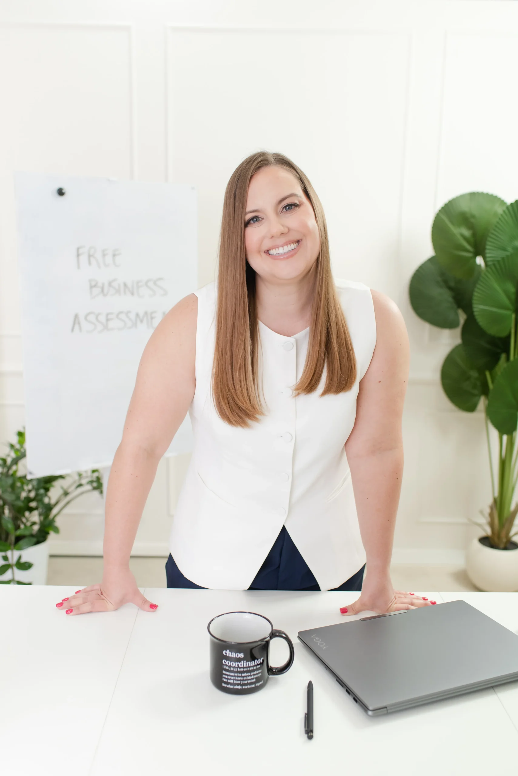 Whitney in White vest in front of "Free Business Assessment" on White Board Whitney in White vest in front of White Board