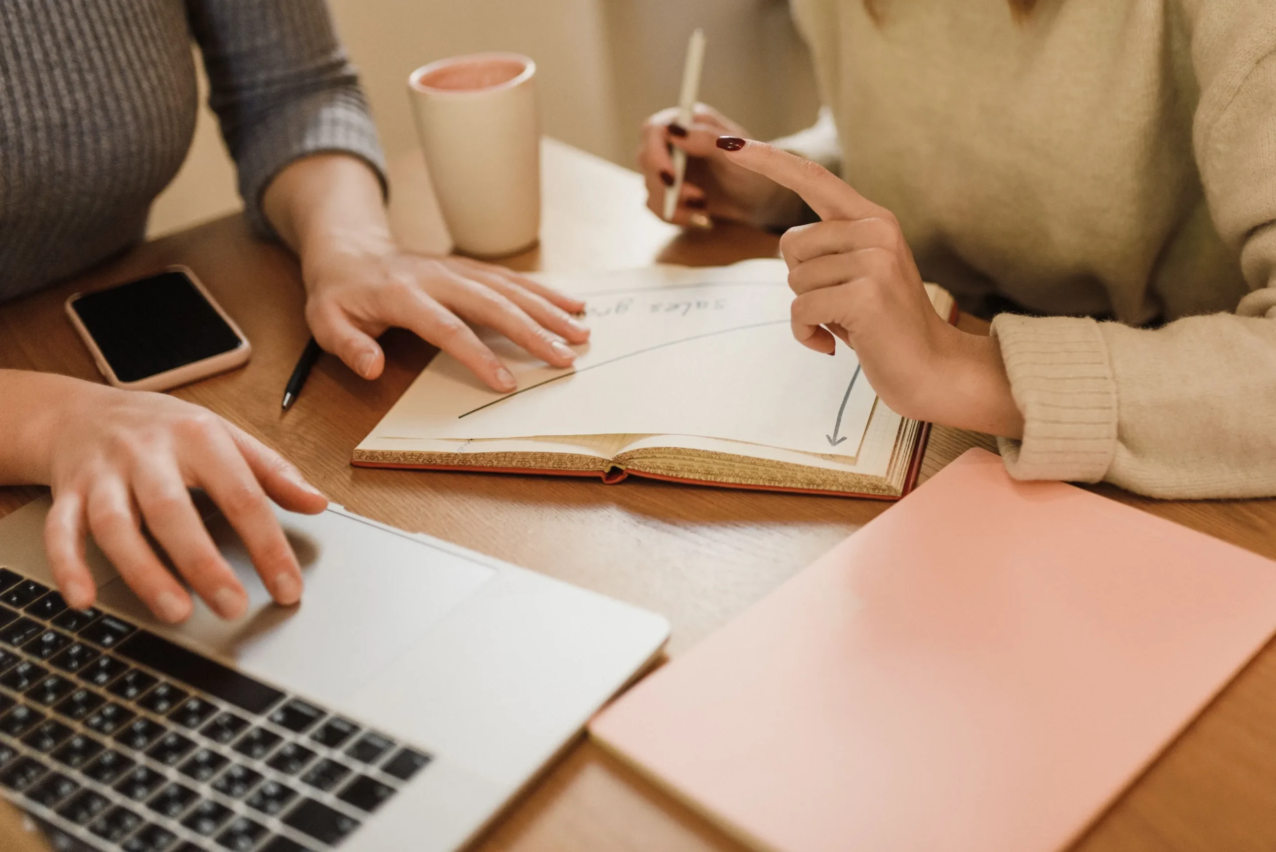 Colleagues Working Together with a Laptop and Notes at a Desk