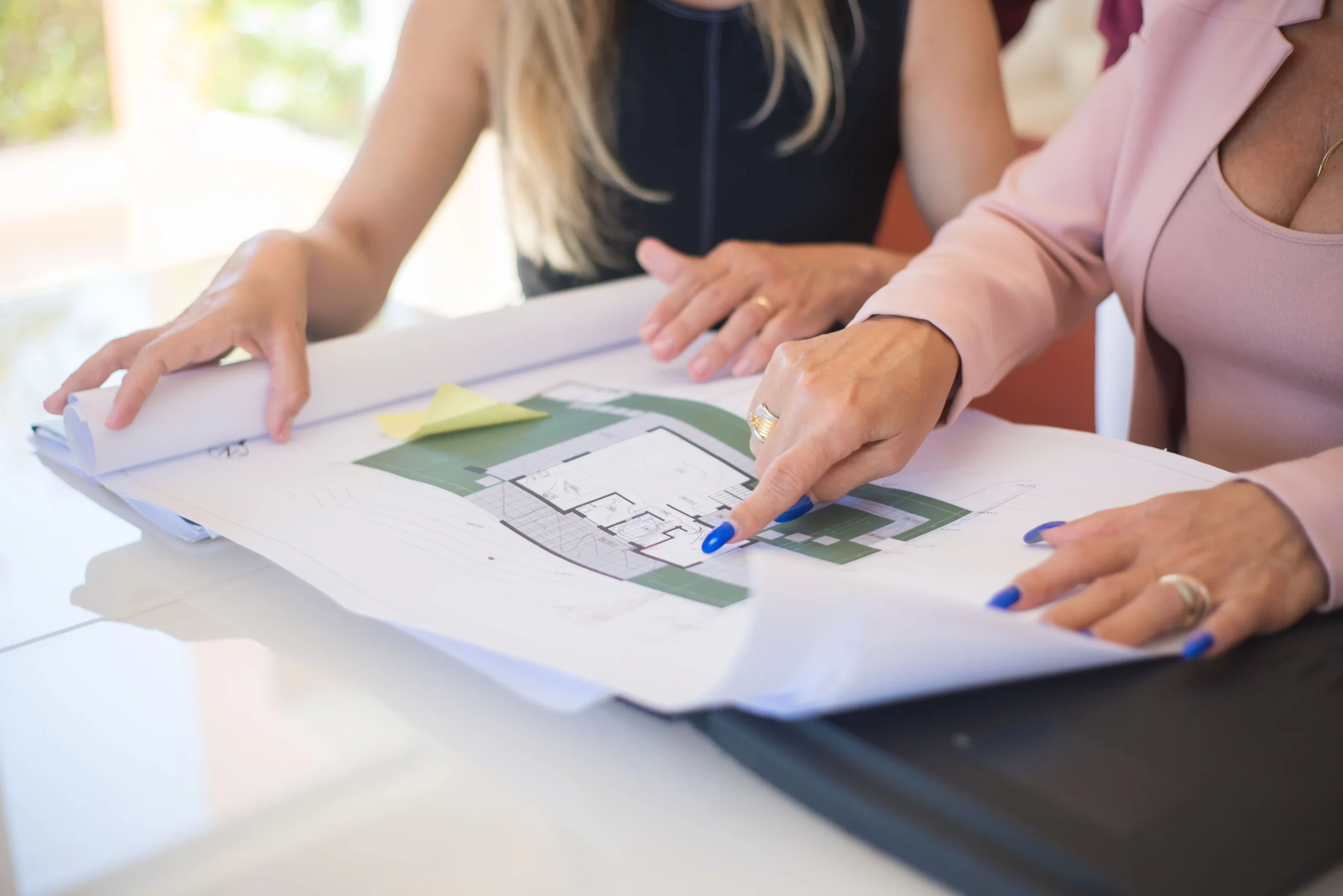 Two Women Review Blueprint in Professional Setting Two Women Review Blueprint in Professional Setting