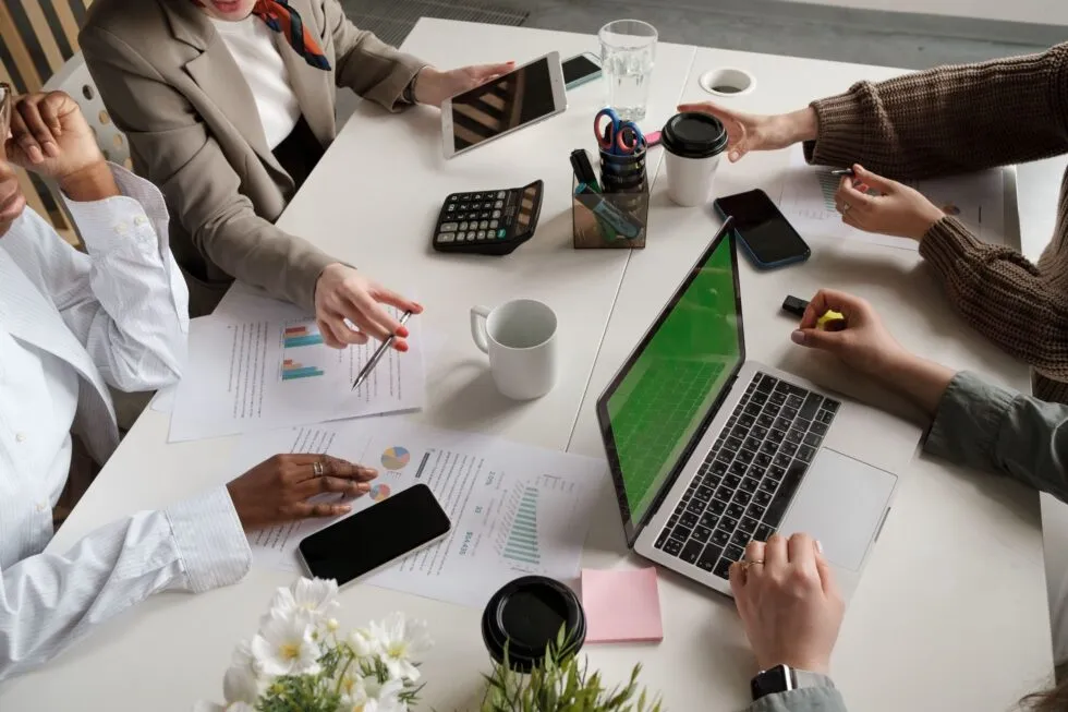 Four People Working Around a Table and Laptop